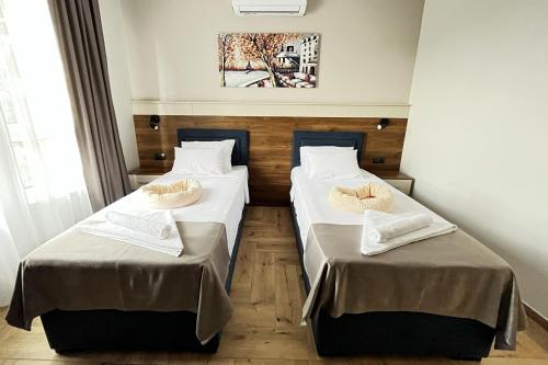 two beds in a room with two bedsvisor at ĆAKA Luxury Rooms & Restaurant in Ćuprija