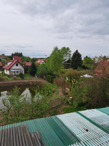 vistas a un patio con una casa y un estanque en OAZA en Olsztyn