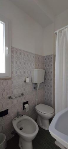 a bathroom with a white toilet and a sink at Hotel Internazionale in Marotta