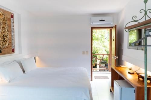 um quarto com uma cama, uma secretária e uma janela em Galeria & Suites Canto do Sol em Barra Grande