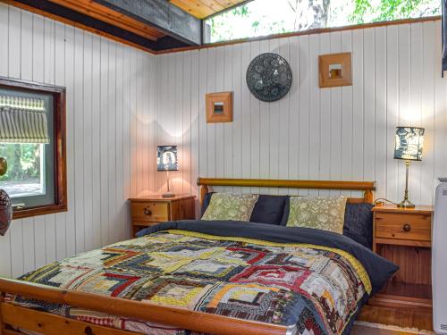 um quarto com uma cama e um relógio na parede em The Cabin em Cenarth