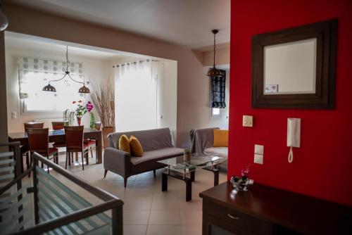 a living room with red walls and a dining room at Holiday Lefkas Moonlight Luxury Appartments in Nikiana