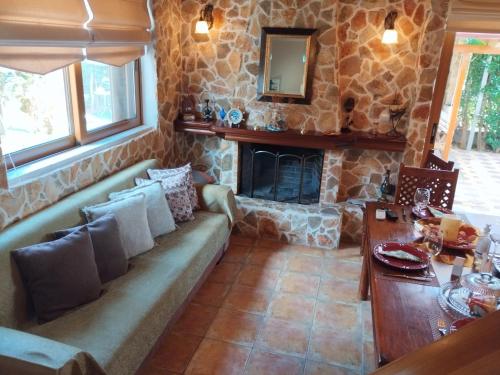 a living room with a couch and a stone fireplace at Luxury Villas Chrysa Private Pool & Spa in Nafplio