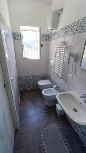 a bathroom with two toilets and a sink and a window at La Dea del Mare in Ischia