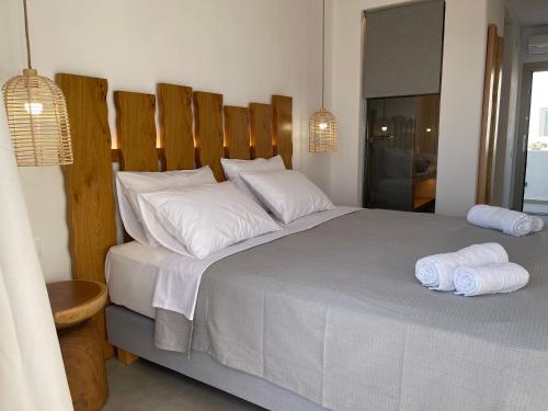 a bedroom with a large bed with two towels on it at Pelagos Studios in Platis Gialos