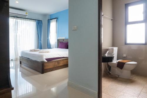 een slaapkamer met een bed en een badkamer met een toilet bij Krabi Lighthouse @ Aonang in Ao Nang Beach