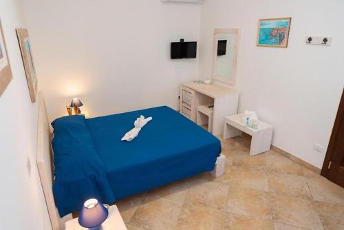 a bedroom with a blue bed with a dog on it at Agriturismo Villa Tommaso in Torre dell'Orso
