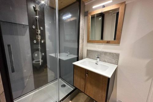een badkamer met een wastafel en een douche bij Charmant chalet Le Bouton D'or in Métabief