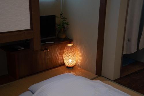a room with a bed and a lamp on the floor at Kyo no Yado Sangen Ninenzaka in Kyoto