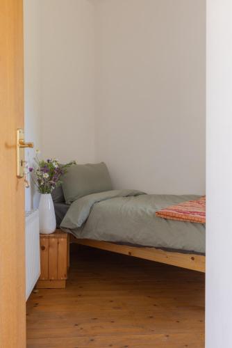 a bedroom with a bed and a vase with flowers at The Common Knowledge Centre in Kilfenora