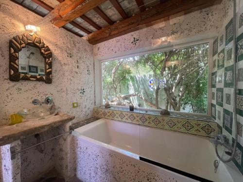 baño con bañera y ventana en Chozito de paja a 300m. playa Mangueta, en El Palmar
