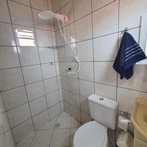 a bathroom with a shower with a toilet and a blue towel at Casa de Campina in Campina Grande