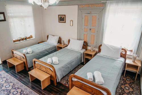 Habitación con 2 camas y 2 sillas. en Guest House Edmond, en Gjirokastra