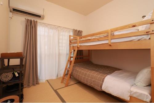 1 Schlafzimmer mit 2 Etagenbetten und einem Fenster in der Unterkunft WAKURIAN,iwatacho - Vacation STAY 98982v in Okayama