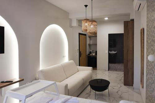 a living room with a white couch and a table at Uphill Unique Boutique Suites in Skiathos Town