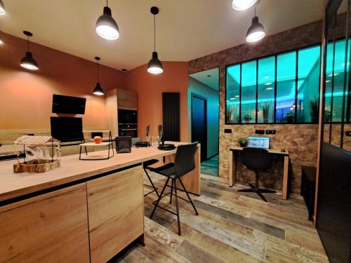Una cocina abierta con escritorio, sillas y ventanas. en Ospaloft, meublé haut de gamme avec spa privatif, en Arras