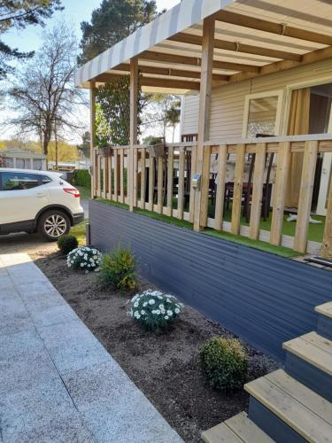 une terrasse couverte sur une maison avec une terrasse en bois dans l'établissement L EVASION, à Pont-Aven