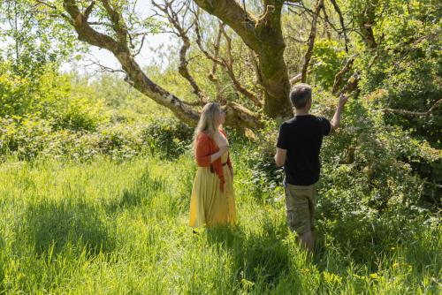 a man and woman standing in a field looking at a tree at The Common Knowledge Centre in Kilfenora