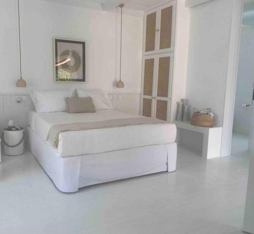 a white bedroom with a large white bed in it at The Bower - Volos FREE DIVING LESSON in Marathos