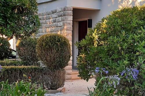 a front door of a house with bushes at Casa com jardim perto da praia in Sesimbra