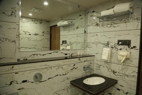 a bathroom with a sink and a mirror at HOTEL HOLISTON in Dwarka