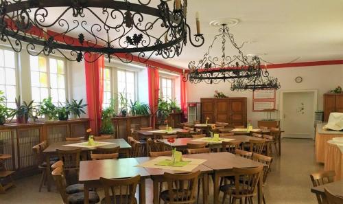 a restaurant with tables and chairs and a chandelier at Jugendhotel Nürnberg in Nürnberg