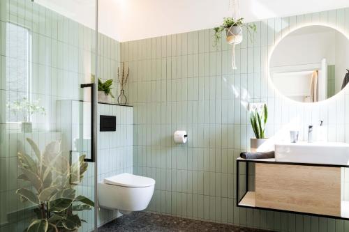a bathroom with a toilet and a sink and a mirror at Urban Jungle Apartments in Vienna