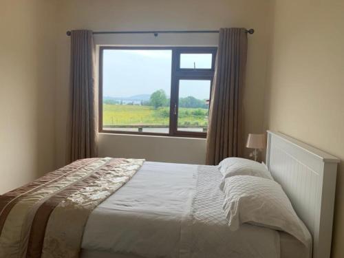 1 dormitorio con cama y ventana grande en Ard Locha - Lake View Apartment, 