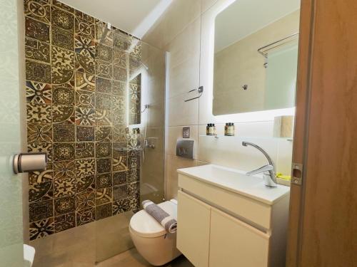een badkamer met een toilet, een wastafel en een douche bij Yulia Luxury Apartment in Ouranoupoli