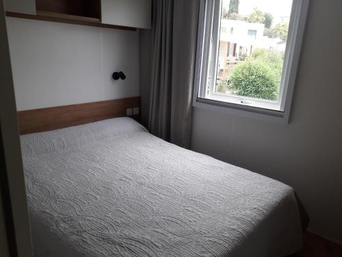 een kleine slaapkamer met een bed en een raam bij Mobil home neuf 3 chambres 8 personnes Fréjus in Fréjus