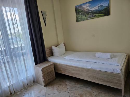 a small bed in a room with a window at Hotel Da Gianni GmbH in Oranienburg