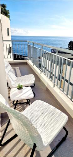 a balcony with two chairs and a view of the ocean at Ocean Pearl Apartment V in Funchal