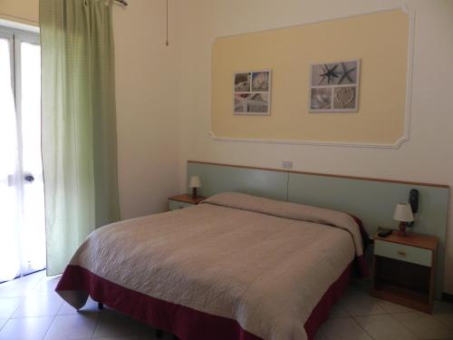 a bedroom with a bed and a window at Hotel Ondina in Viareggio