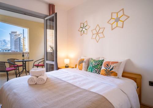 a bedroom with a large bed with towels on it at Villa Maxima Budva in Budva