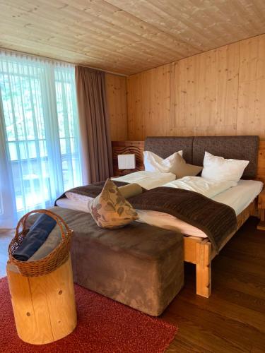 a bedroom with a large bed and a large window at Spa Hotel Zedern Klang in Hopfgarten in Defereggen