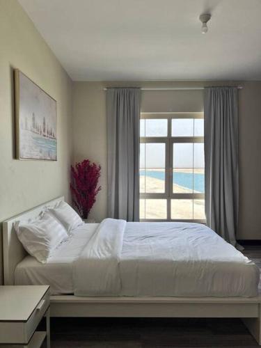 a bedroom with a large bed and a window at Nazeel - Sea view Marina Apt in King Abdullah Economic City