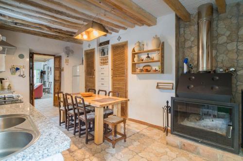 a kitchen with a wooden table and a fireplace at Cortijo Don Simón in Córdoba