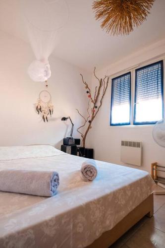 une chambre avec un grand lit blanc avec des serviettes dessus dans l'établissement Villa ALOHA-65m2 garden/Swimmingpool - 500m Beach, à Moriani-Plage