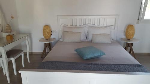 a bedroom with a large white bed with two tables at Kerasies Studios in Patitiri