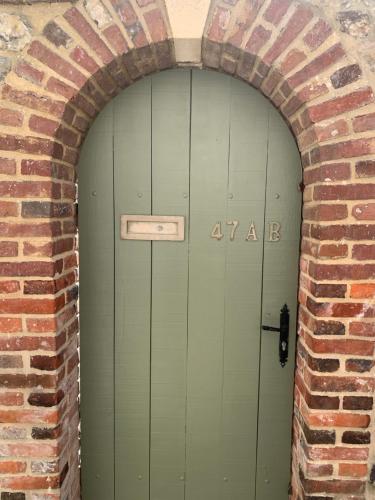 une arche avec une porte verte dans un mur de briques dans l'établissement Honfleur effet mer 2, à Honfleur