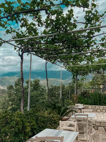 a group of tables with a view of the mountains at ELÉA Guesthouse himare in Himare