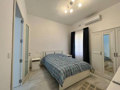 ein Schlafzimmer mit einem Bett und einem begehbaren Kleiderschrank in der Unterkunft Brand new 3-level sea view apartment near beach in Il-Pergla