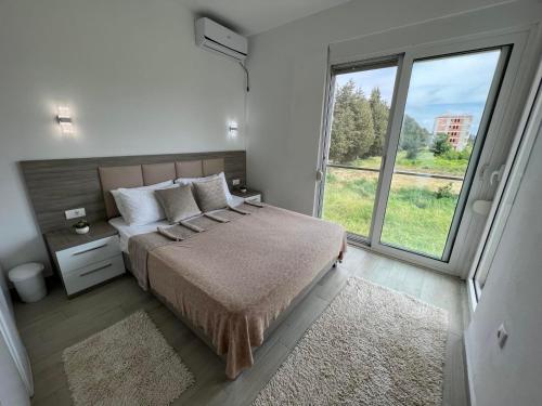 um quarto com uma cama e uma grande janela em Rasi Luxury Apartments em Ulcinj
