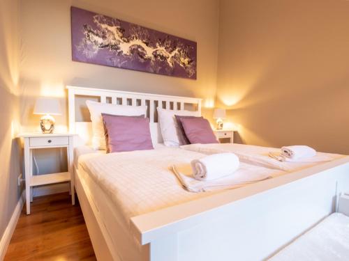 een slaapkamer met een groot wit bed met handdoeken erop bij EUPHORAS - Central & Stylish Apartment - Parking in Bad Harzburg
