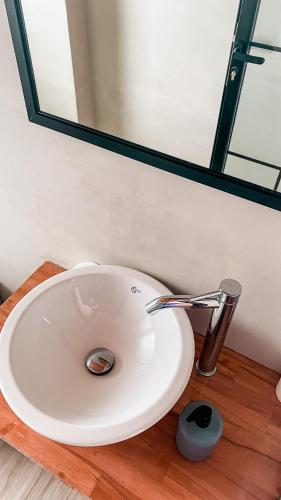 a white sink in a bathroom with a mirror at ELÉA Guesthouse himare in Himare