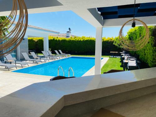 a pool with chairs and a table and a swimming pool at HESTİA ILICA in Cesme