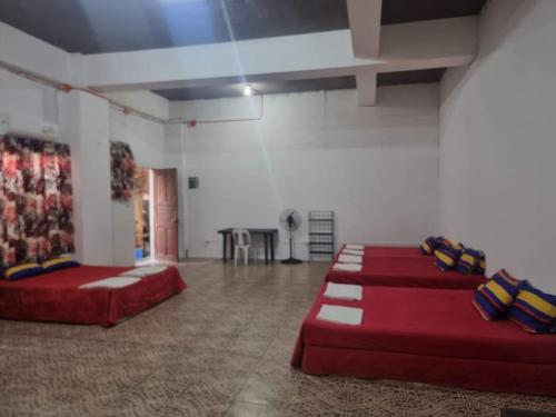 Habitación grande con sofás rojos y mesa. en Villa violeta beach resort en San Juan