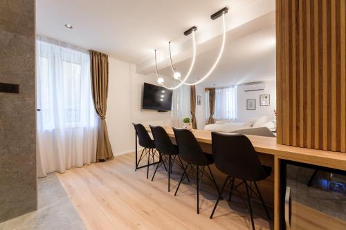 una sala da pranzo con un lungo tavolo e sedie nere di Harmony - Luxury room a Spalato (Split)