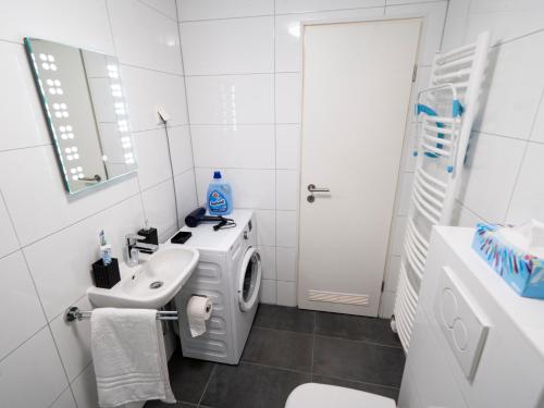 a white bathroom with a sink and a washing machine at TRUTH - Kingsize Bett - Smart TV - Modern - Top Anbindung in Dortmund