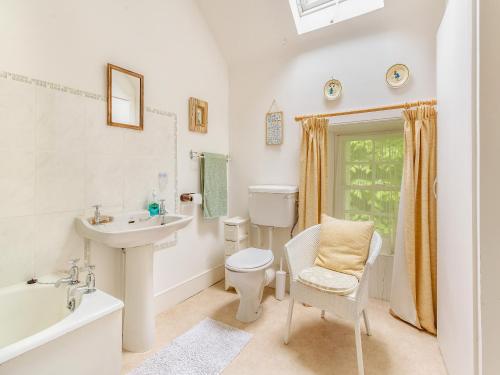 a bathroom with a sink and a toilet and a tub at The Cottage in Slickly